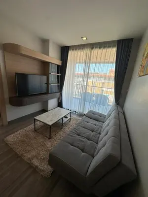 a living room with a couch and a flat screen tv at 2 комнатные апартаменты с одной спальней и кухней-гостиной in Phuket Town
