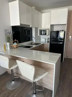 a kitchen with a white counter and a black refrigerator at 2 комнатные апартаменты с одной спальней и кухней-гостиной in Phuket Town