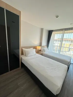 a hotel room with two beds and a window at 2 комнатные апартаменты с одной спальней и кухней-гостиной in Phuket Town