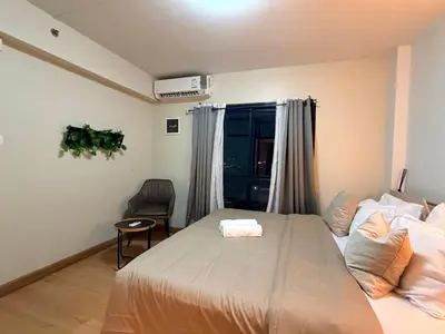 a bedroom with a large bed and a window at 1BR Apartment Suite in the heart of Phuket Town in Ban Lo Long