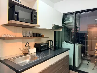 a kitchen with a sink and a microwave and a refrigerator at 1BR Apartment Suite in the heart of Phuket Town in Ban Lo Long