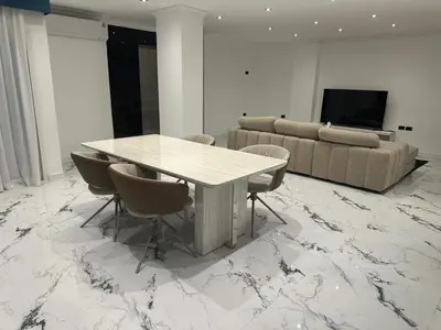 a living room with a table and a couch at Elite Luxury Apartment Patong in Patong Beach