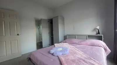 a bedroom with a bed with a stuffed animal on it at Phuket villa airport in Nai Yang Beach
