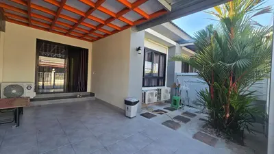 a patio with a table and a palm tree at Joyful House Naiyang beach in Thalang