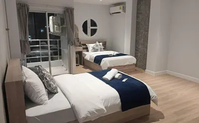 a hotel room with two beds and a television at Global Hills Hotel in Patong Beach