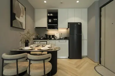 a kitchen with a table with chairs and a refrigerator at Title Legendary Apartment 800m to Bang Tao Beach in Bang Tao Beach
