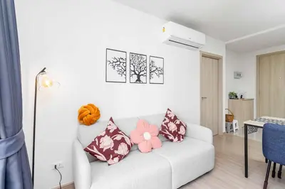 a living room with a white couch with pink pillows at C262 Relax 2BR Condo with Pool and Full Gym in Kathu