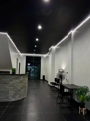 a hallway with a table and chairs in a building at Atrium Kathu Hotel in Ban Kathu
