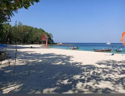 a beach with a group of people and boats in the water at patong see view condo in Patong Beach