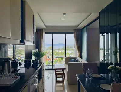 a kitchen with a view of a living room at Ocean Breeze 1-BR apartment, Sea View, Surin beach in Ban Lum Fuang
