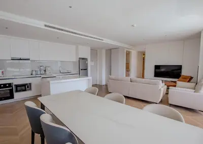 a kitchen and living room with a table and chairs at Kora 267 3BR Condo with Pool View in Phuket Town