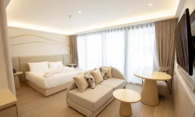 a hotel room with a couch and a bed at One Bedroom Wyndham Naithon with Jacuzzi in Phuket Town