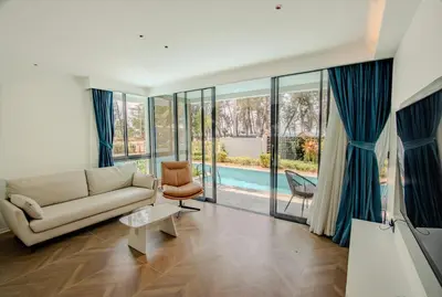 a living room with a couch and a pool at Kora 77 2BR Beachfront Condo with Sea View and Pool in Phuket Town