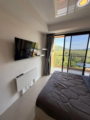 a bedroom with a large bed and a large window at The Signature Studio at Mai Khao by FAMILY HOMES CB-846 in Ban Mai Salae