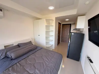 a bedroom with a bed and a flat screen tv at The Signature Studio at Mai Khao by FAMILY HOMES CB-846 in Ban Mai Salae
