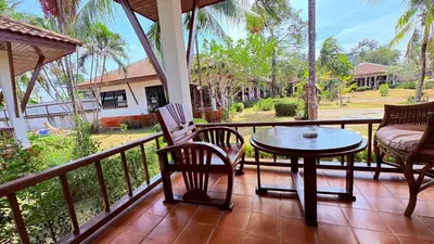 a patio with a table and chairs on a balcony at เดอะ รินรา กมลา ฮัท in Kamala Beach