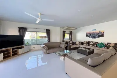 a living room with a couch and a flat screen tv at Grand Villa Ishu 4BR Private Pool in Kamala Beach