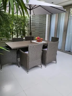 a table and chairs with an umbrella on a patio at Naithon Beach Pearl of Naithon in Nai Thon Beach