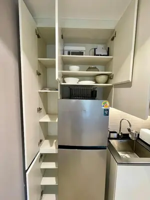 a refrigerator in a kitchen with white cabinets at Title Legendary Apartment 1 Bdr Bang Tao in Bang Tao Beach