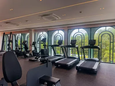 a gym with treadmills and ellipticals in a room with windows at Title Legendary Apartment 1 Bdr Bang Tao in Bang Tao Beach