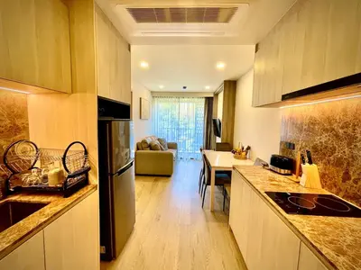 a kitchen with a counter and a living room at The Ozone Residences Bangtao Beach 1Bdr in Laguna Phuket
