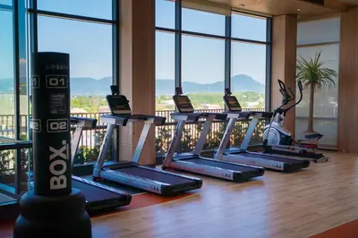 a row of treadmills in a gym with windows at Lovely 2 Bdr Canvas BangTao in Laguna Phuket
