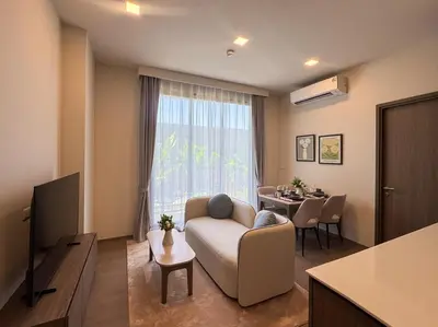 a living room with a couch and a table at Lovely 2 Bdr Canvas BangTao in Laguna Phuket