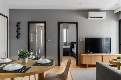 a living room with a dining table and a television at Suite Valencia 2BR The Title IBG Legendary BangTao in Laguna Phuket