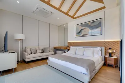 a bedroom with a large bed and a couch at New 4 bedroom villa 700 meters to Bang Tao Beach in Ban Thalat Choeng Thale
