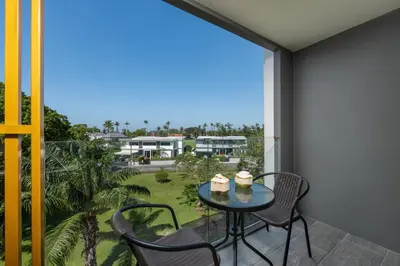 a patio with a table and chairs on a balcony at Suite Anafi 2BR Pool Gym Access Ozone in Laguna Phuket