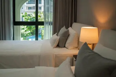 a bedroom with a white bed and a window at Luxury 2 bdr Title Legendary Bang Tao Pool View in Bang Tao Beach