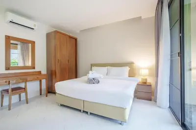 a bedroom with a large white bed and a desk at 1 Bedroom Villa - 2 Minutes to Nai Harn Beach A103 in Rawai Beach
