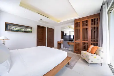 a bedroom with a bed and a couch and a television at Villa love with a garden in Phuket