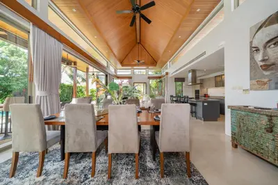 a dining room with a wooden table and chairs at Villa love with a garden in Phuket
