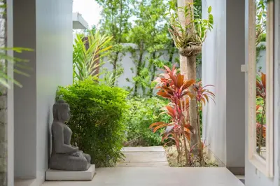 an entrance to a garden with a statue sitting on a porch at Villa love with a garden in Phuket