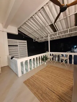 a living room with a table and chairs and a ceiling at The Lighthouse Seaview Hotel in Rawai Beach