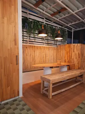 a table and bench in a room with wooden walls at The Lighthouse Seaview Hotel in Rawai Beach