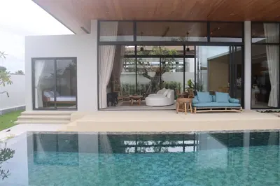 a house with a swimming pool next to a house at Botanica Four Season Luxury Pool Villa in Phuket