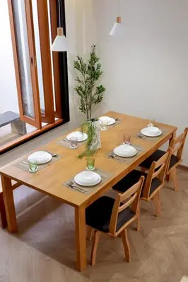 a wooden table with chairs and plates and a plant on it at Tree House in Ban Rangeng