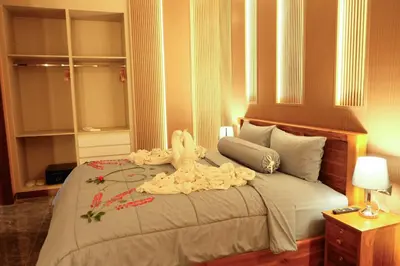 a hotel room with a bed with flowers on it at Bauman Residence in Patong Beach