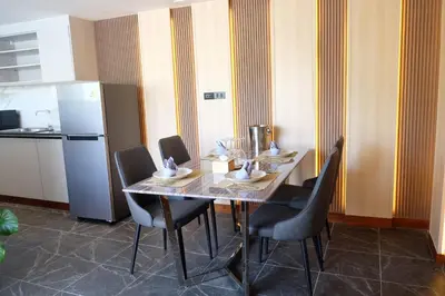 a dining room with a table with chairs and a refrigerator at Bauman Residence in Patong Beach