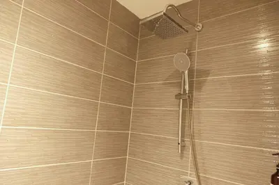 a shower with a shower head in a bathroom at Bauman Residence in Patong Beach