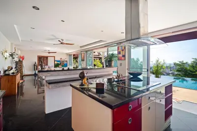 an open kitchen with a view of a pool at Kata Seaview Villa in Ban Karon