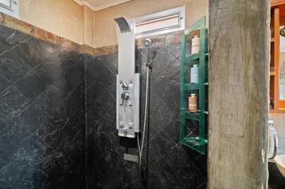 a bathroom with a shower with a green shelf at Kata Seaview Villa in Ban Karon