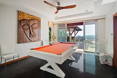 a pool table in a living room with a painting at Kata Seaview Villa in Ban Karon