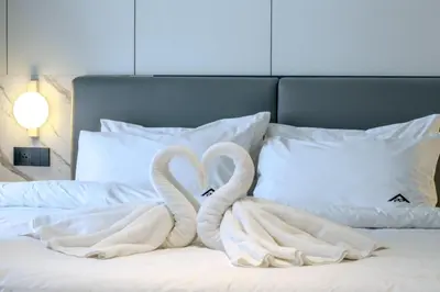 two swansrendered to look like swans on a bed at KORA 243 One-Bedroom Residence in Phuket Town