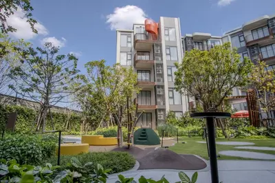 a apartment building with trees in front of it at Canvas 11112 Cozy 2BR Residence in Phuket Town