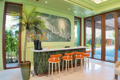 a room with a bar with orange stools at Canvas 11112 Cozy 2BR Residence in Phuket Town