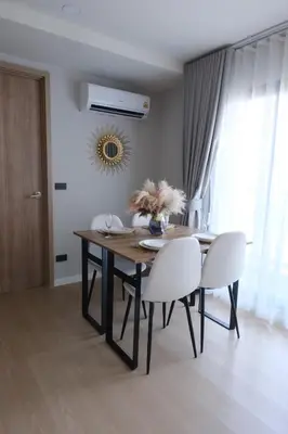 a dining room with a table and white chairs at Stylish 2BR condo in the heart of Bang Tao in Ban Thalat Choeng Thale