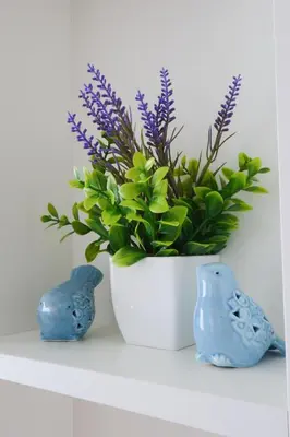 two blue birds and a white vase with a plant at Stylish 2BR condo in the heart of Bang Tao in Ban Thalat Choeng Thale